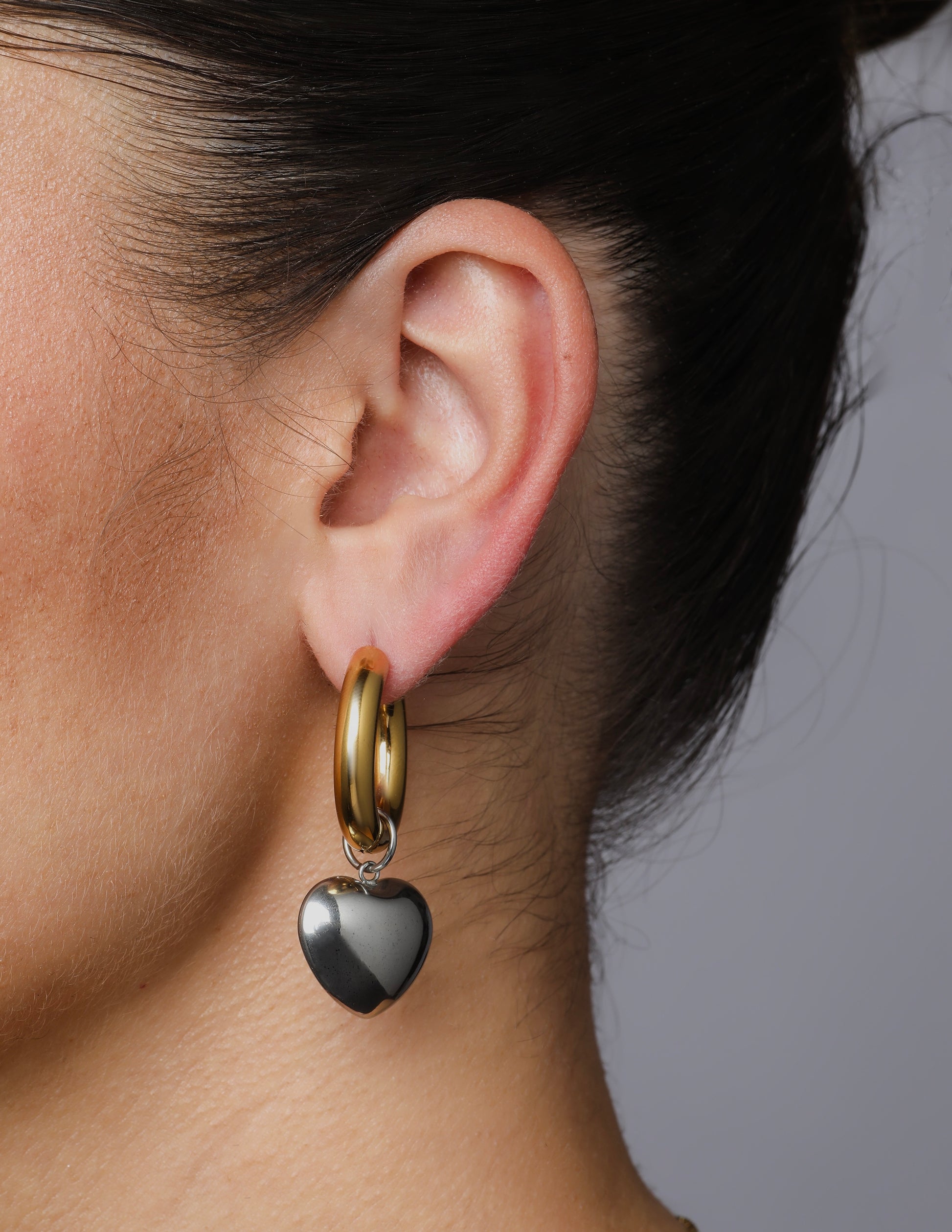 Chunky gold hoop earrings with silver heart charms – moody mixed-metal statement jewellery